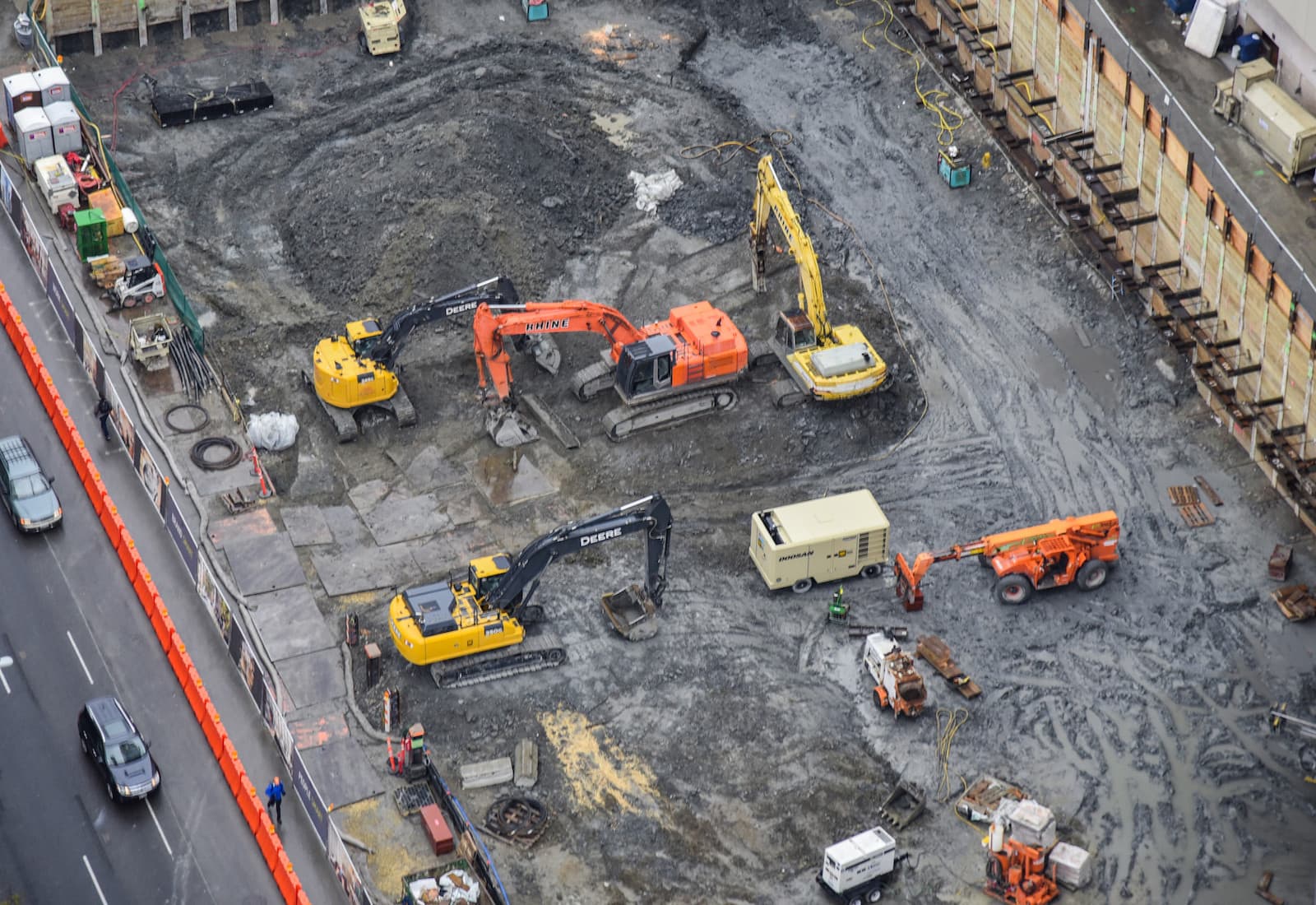high angle aerial view of a construction site with large tractors cranes bulldozes and backhoes