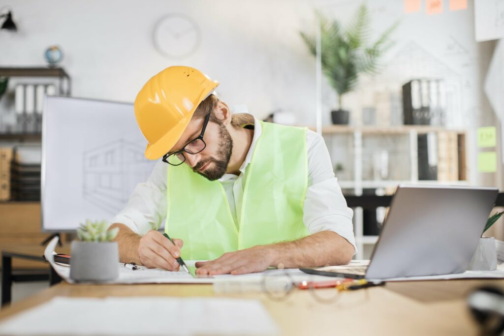 Male builder and construction worker looking through documents