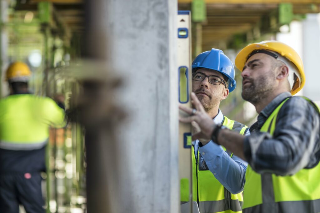 project manager and construction worker-using spirit level